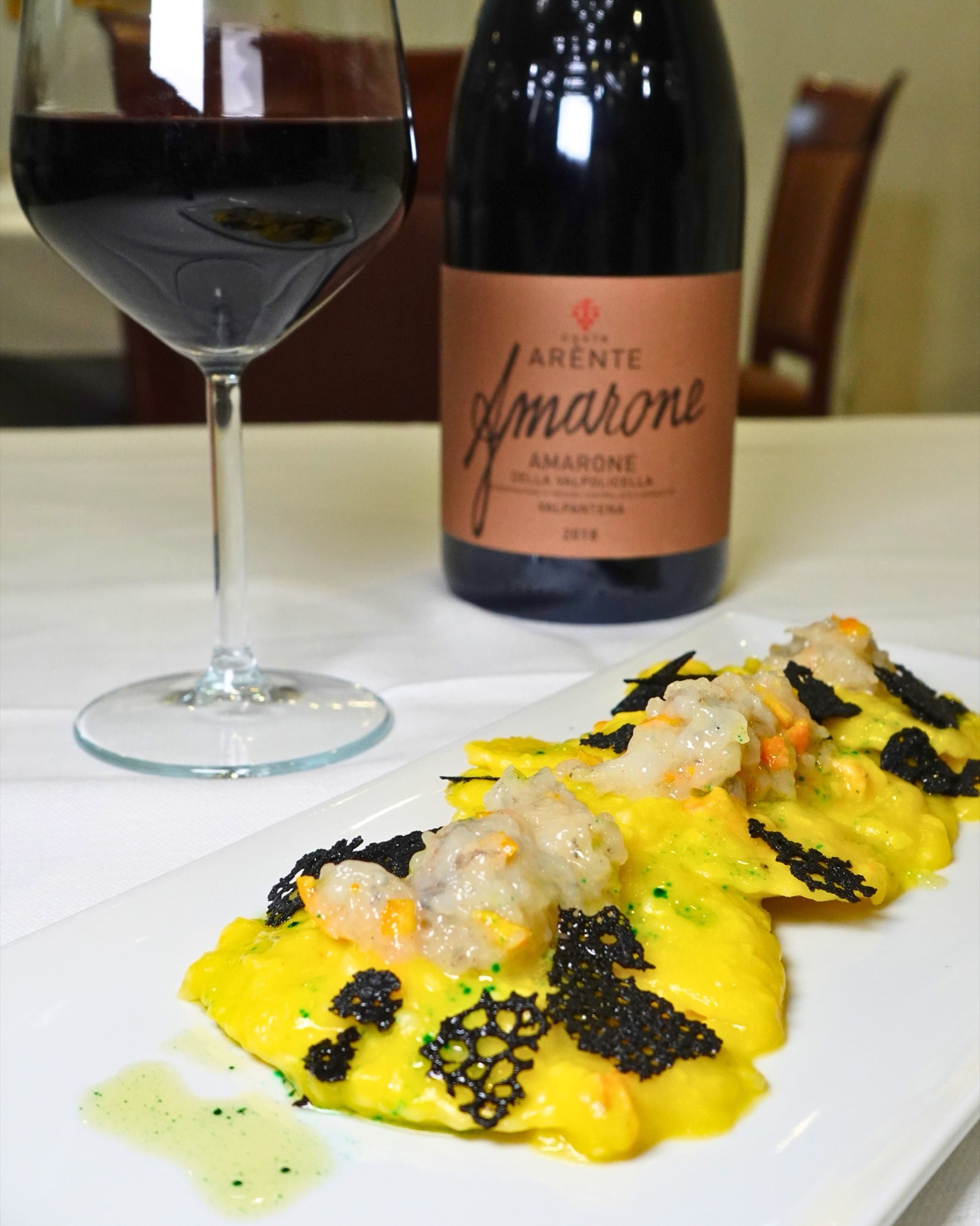 Ravioli ai gamberi serviti con Amarone