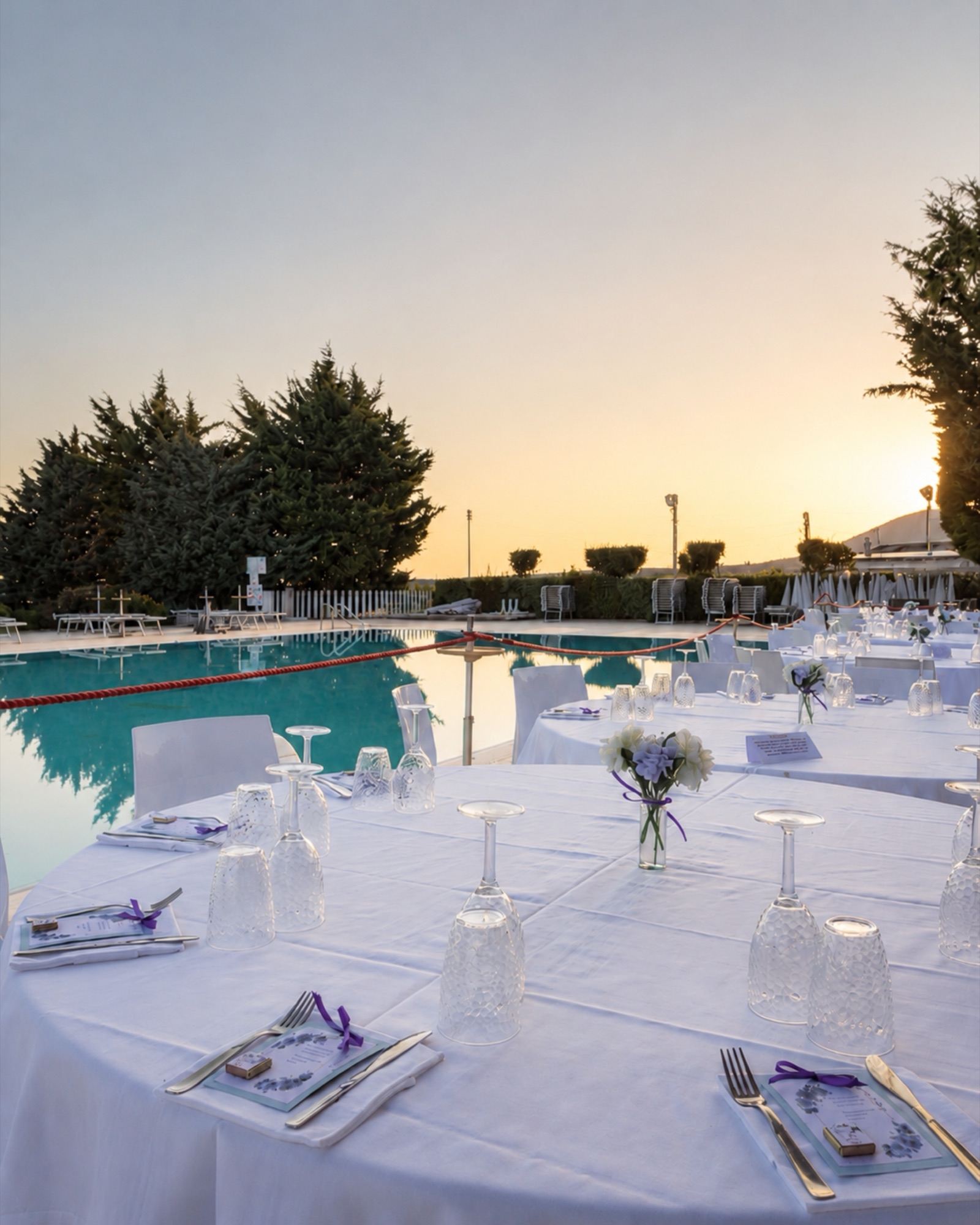 Tavolata allestita a bordo piscina al tramonto