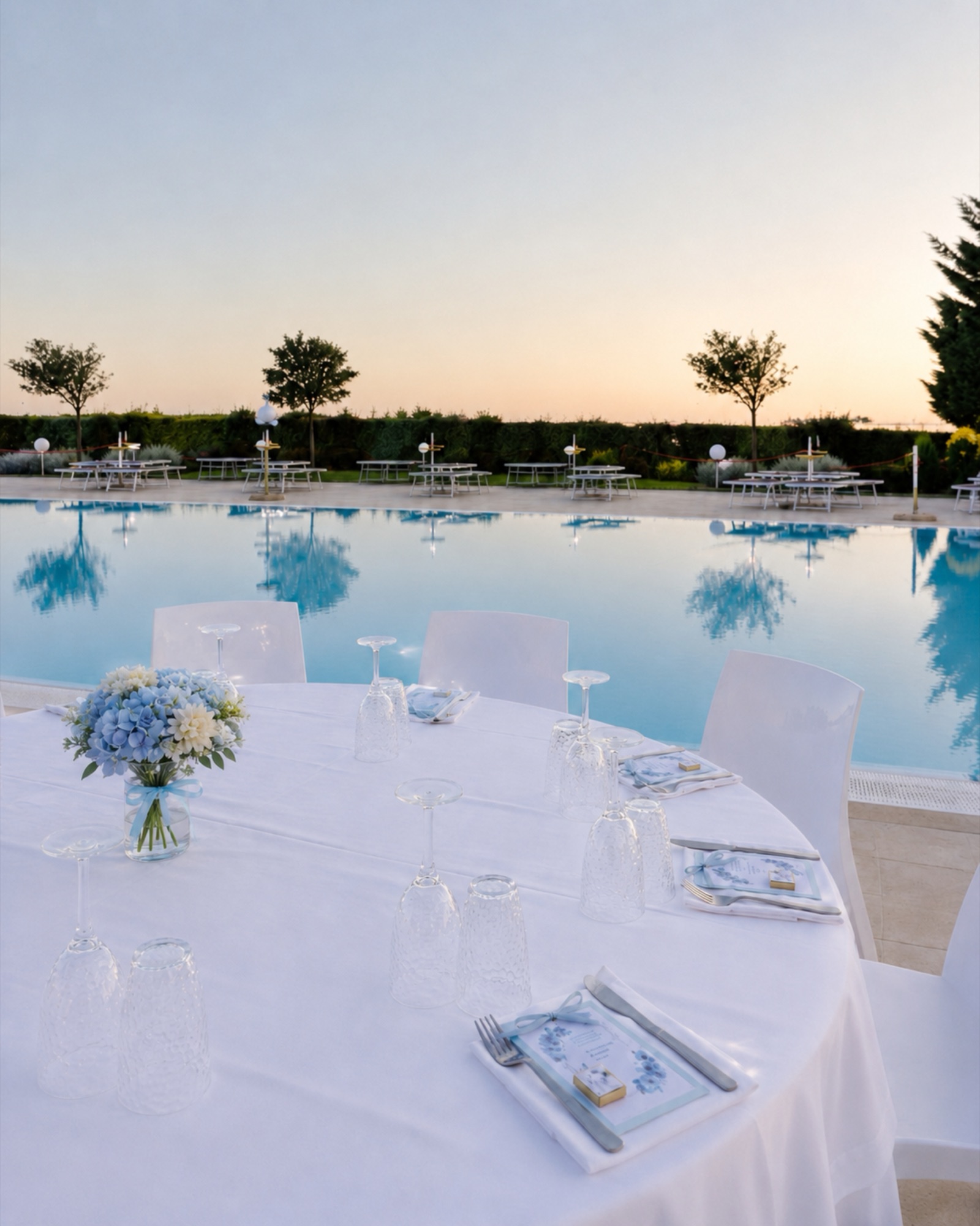 Tavolo apparecchiato con la piscina al tramonto