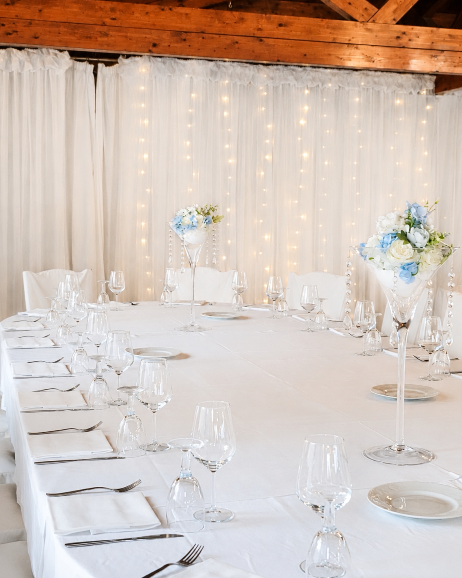 Tavolata allestita in sala con luci e fiori